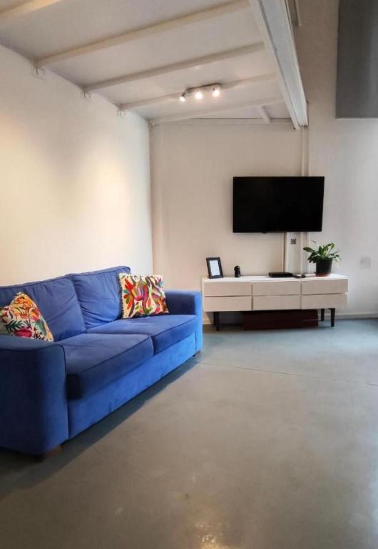 a living room with a blue couch and a tv at Departamento MOCA - Full Amenities in Buenos Aires