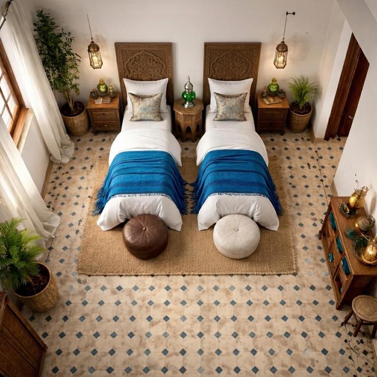 two beds in a room with two ottomans at Villa El Houda in Souk el Had du Drâa