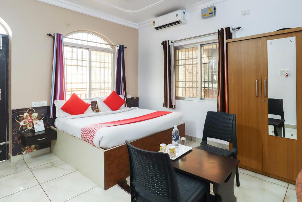 a bedroom with a bed and a desk and a table at Capital O The Tulip in Rānchī