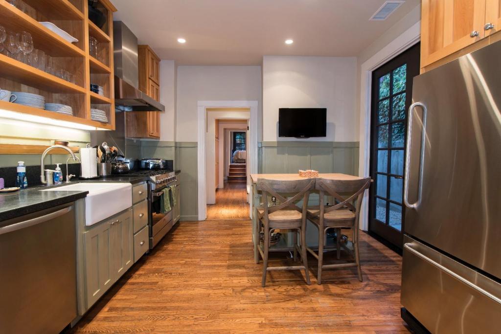 a kitchen with a table and a refrigerator at Magnolia Cottage in Santa Barbara