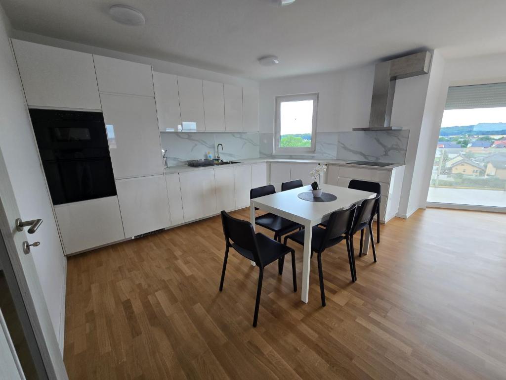 a kitchen with a table and chairs in a room at Apartma Tri Srca Radenci 3 sobe in Radenci