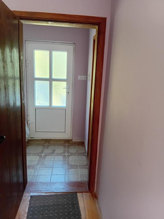 an empty hallway with a door and a window at Ljiljana Apartman 1 in Rakari