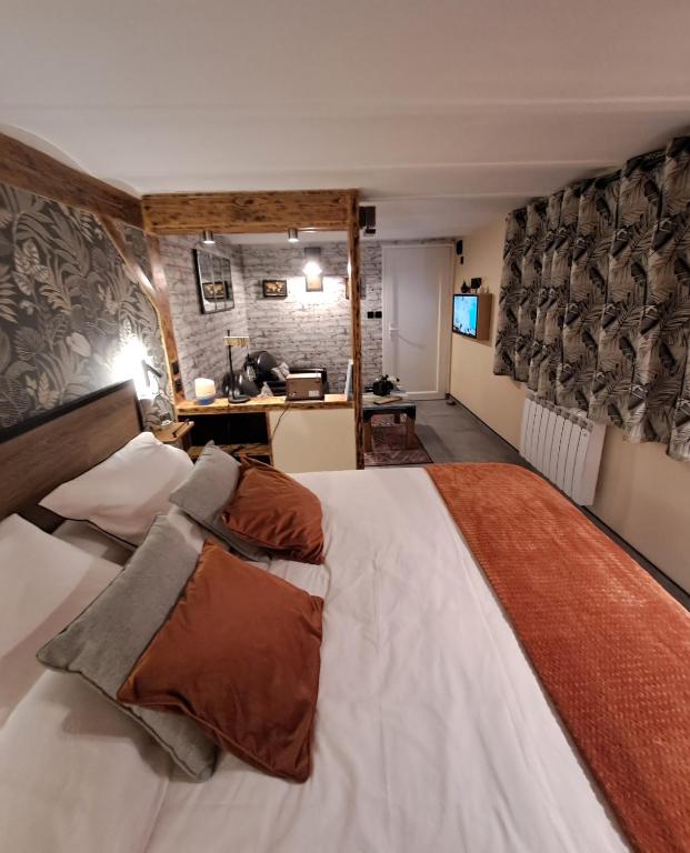 a bedroom with a large bed and a desk at le patio de la Cavée " havre de paix" in Verderonne