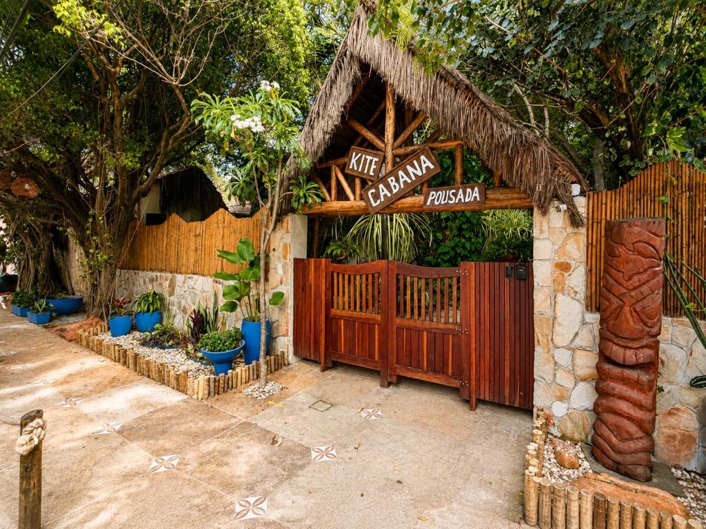 a restaurant with a wooden gate and a fence at Kitecabana Pousada in Cumbuco