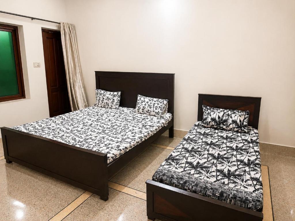 two beds sitting next to each other in a room at Timber Box Hostels in Rawalpindi