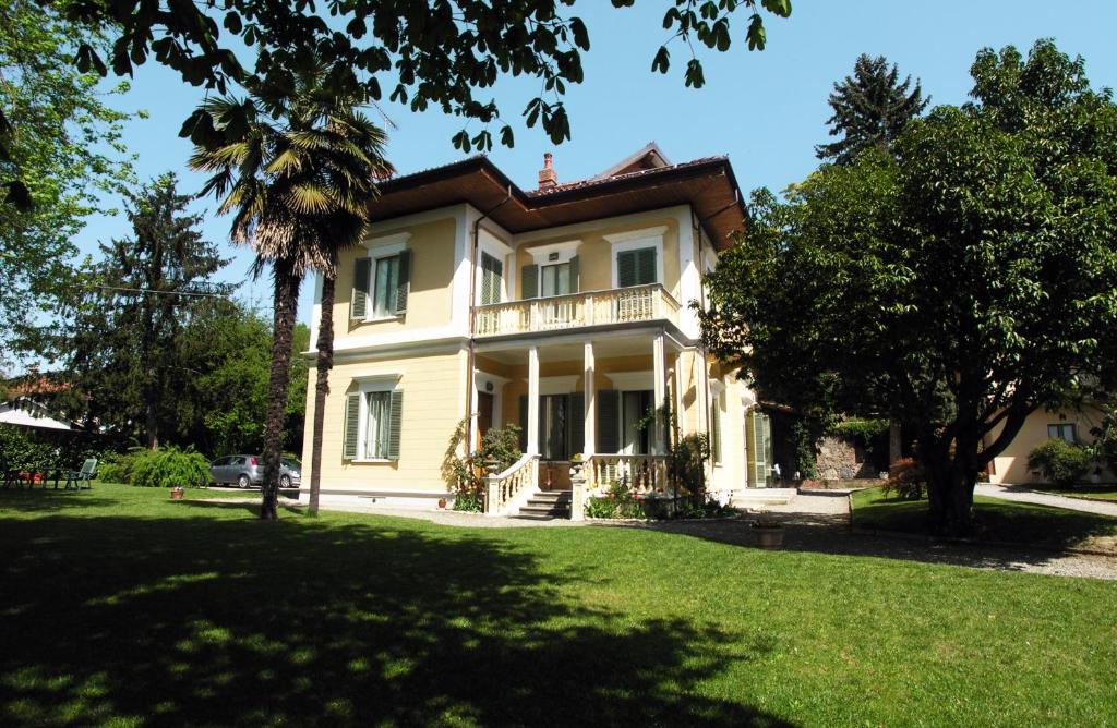 a large house with a palm tree in front of it at Villa D'Azeglio in Albiano dʼIvrea