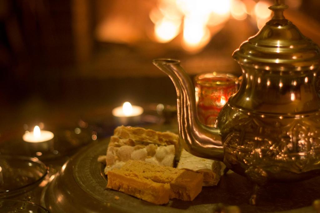 a plate with a piece of food on a table with candles at Jamarauja in Biar