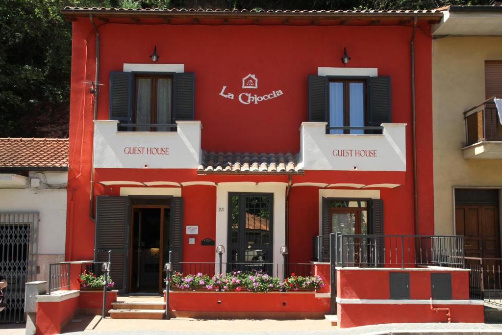 a red building with flowers in front of it at La Chioccia in Valmontone