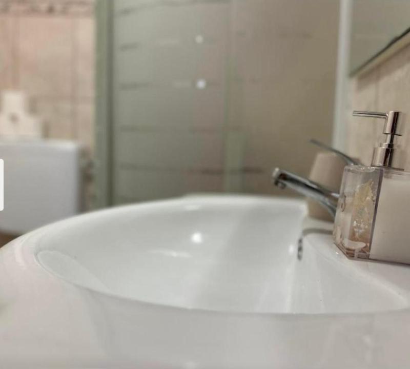 a bathroom with a white sink with a faucet at Stunning Sea View in Central Postira in Postira