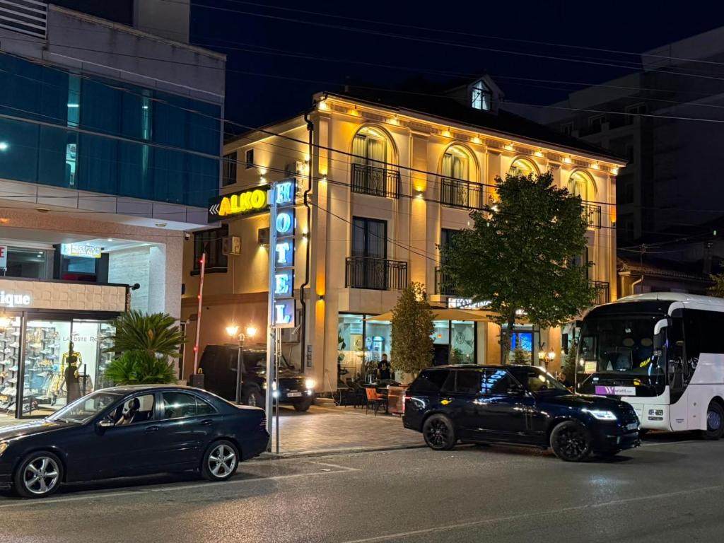 two cars parked in front of a building at night at Alko Hotel Shkoder in Shkodër