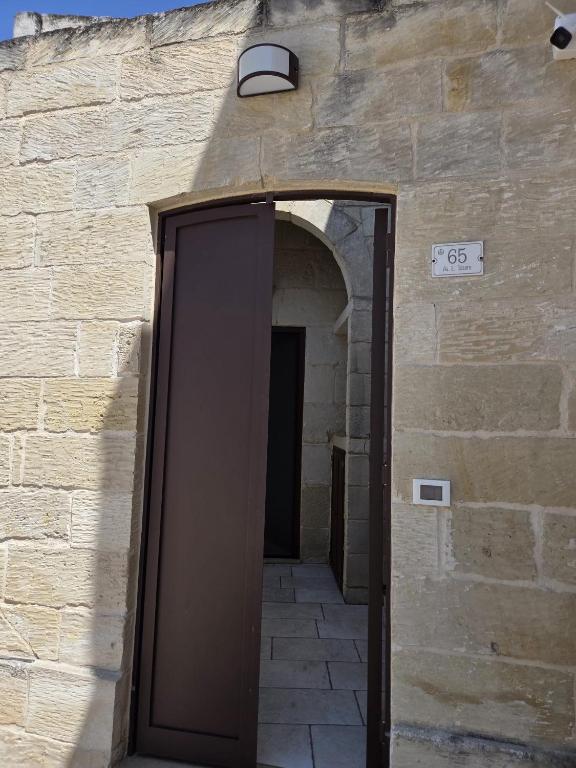 an entrance to a building with a brown door at Casa Vacanza Largo 65 in Scorrano