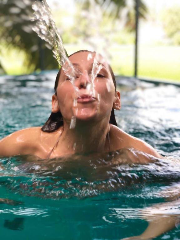 a woman in a swimming pool with water pouring on her face at 47 - Your Ultimate Relaxation in Colombo in Pannipitiya