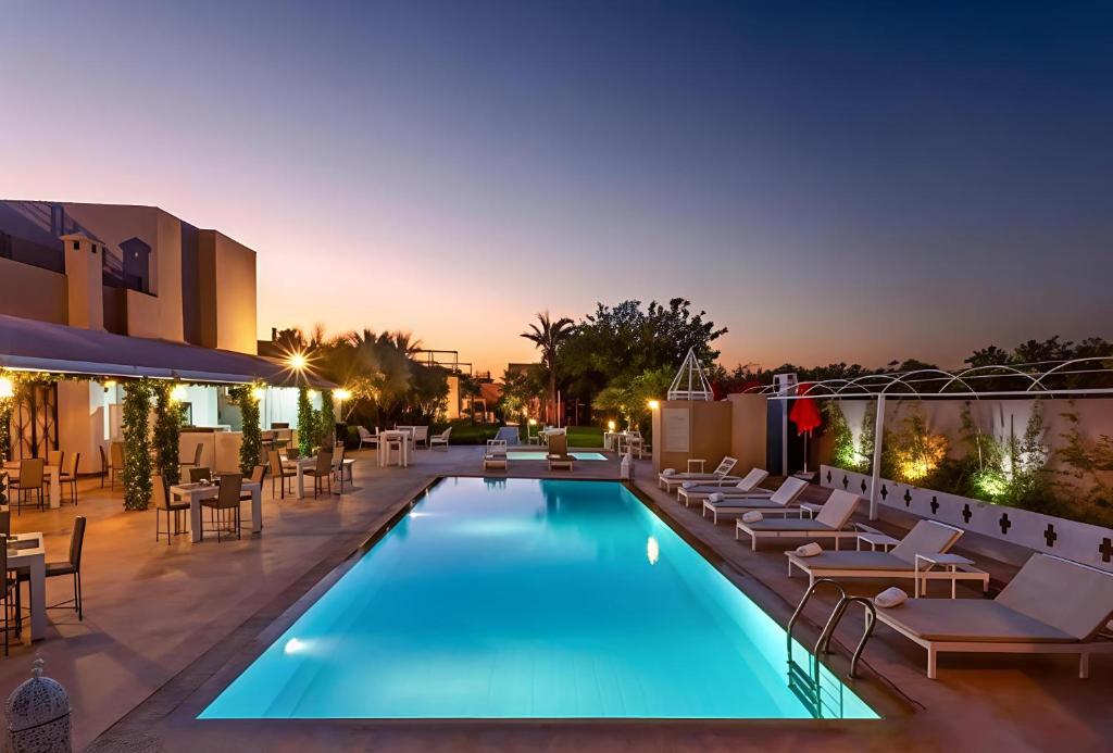 a swimming pool with lounge chairs and a hotel at Palais Jena Hotel & Spa in Marrakesh