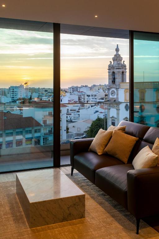 a living room with a couch and a view of a city at The Downtown Largo do Carmo in Faro