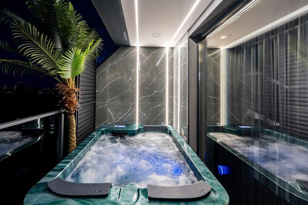 a bath tub in a room with a palm tree at Beni Deluxe 2 in Plovdiv