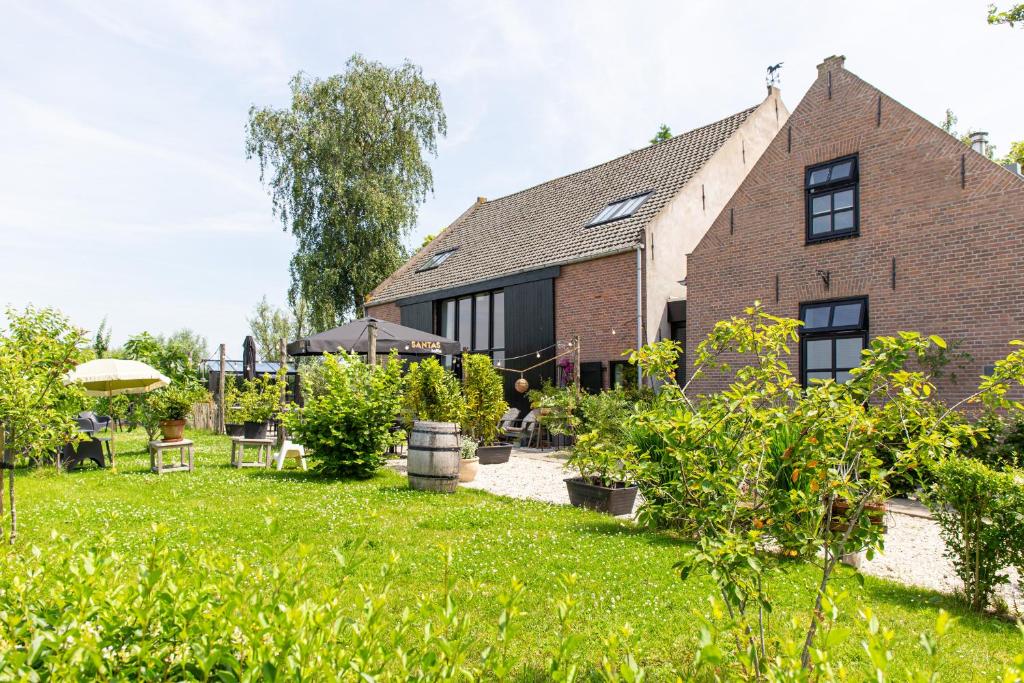 an old brick house with a garden in front of it at De Zuileshoeve in Dordrecht