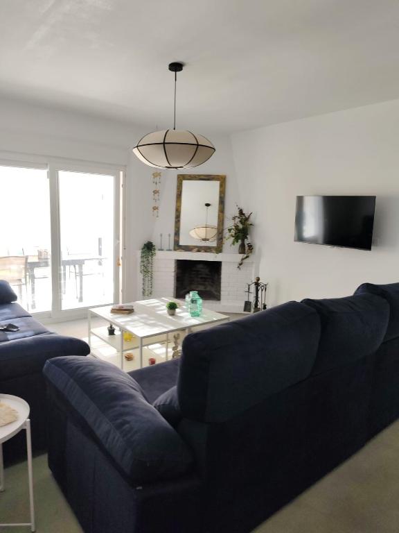 a living room with a blue couch and a tv at La OSTRA 33 in Chiclana de la Frontera