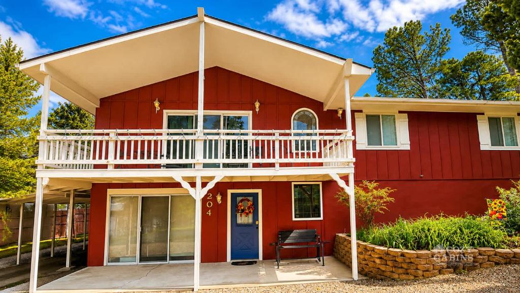 a red house with a deck and a balcony at Chalet Rouge in Ruidoso