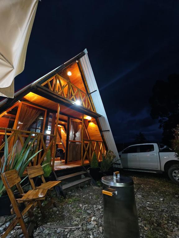a house with a truck parked outside of it at night at Cabaña El Resguardo in La Capilla