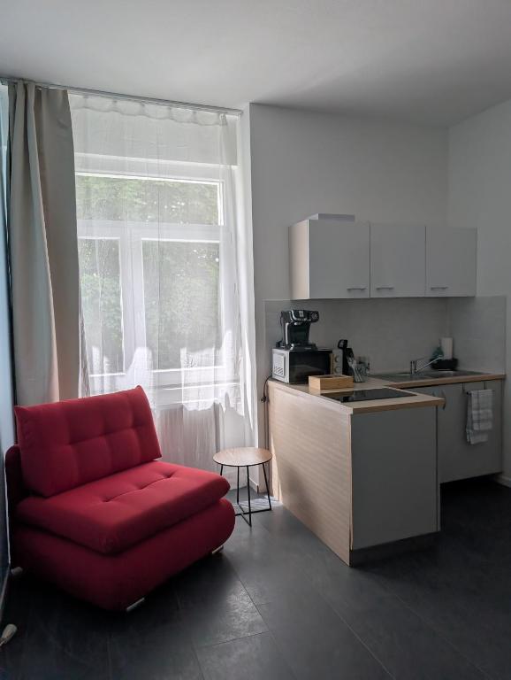 a kitchen with a red chair and a kitchen counter at Royal Racing Suite Top 3 near Red Bull Ring in Judenburg