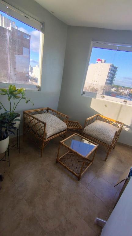 a living room with two chairs and two windows at NAT home in San Lorenzo