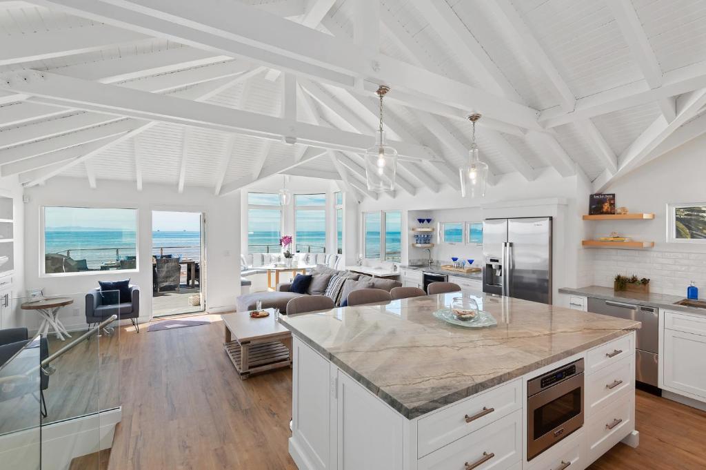 a kitchen and living room with a view of the ocean at Sandcastle in Carpinteria