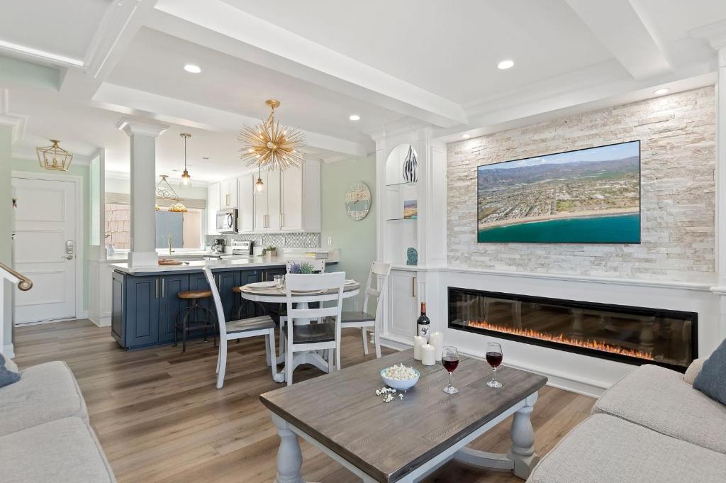 a living room with a fireplace and a table at Sandbox at Solimar Sands in Carpinteria