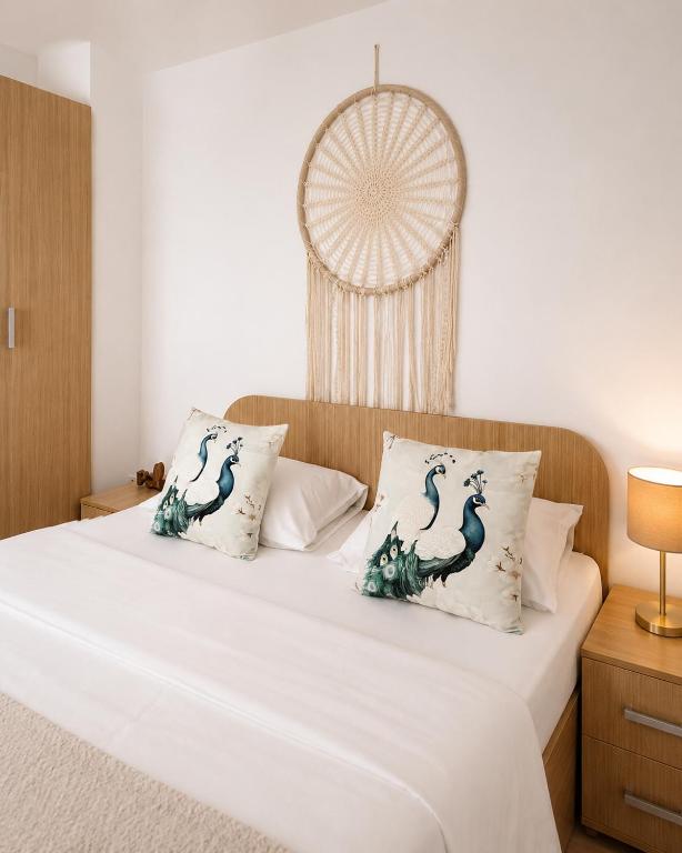 a bedroom with a white bed with two pillows at Fly Airport Residences & Therme-SELF CHECK-IN in Otopeni