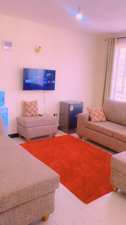 a living room with two couches and a red rug at Moh airbnbs in Kisumu