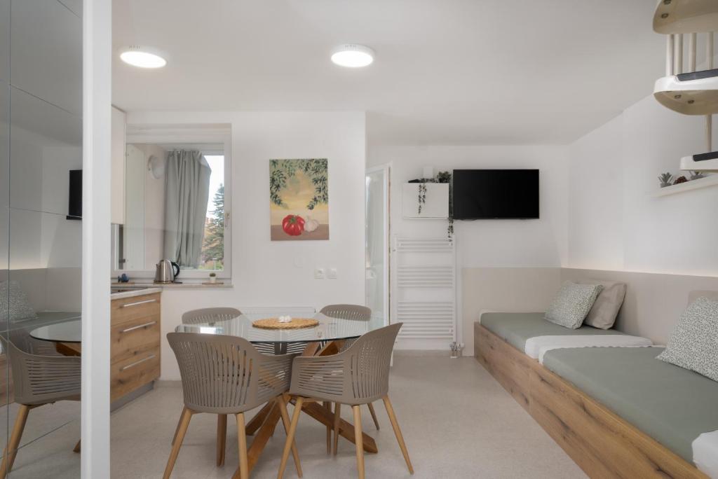 a kitchen and living room with a table and chairs at Sunny Apartment with Terrace in Ankaran