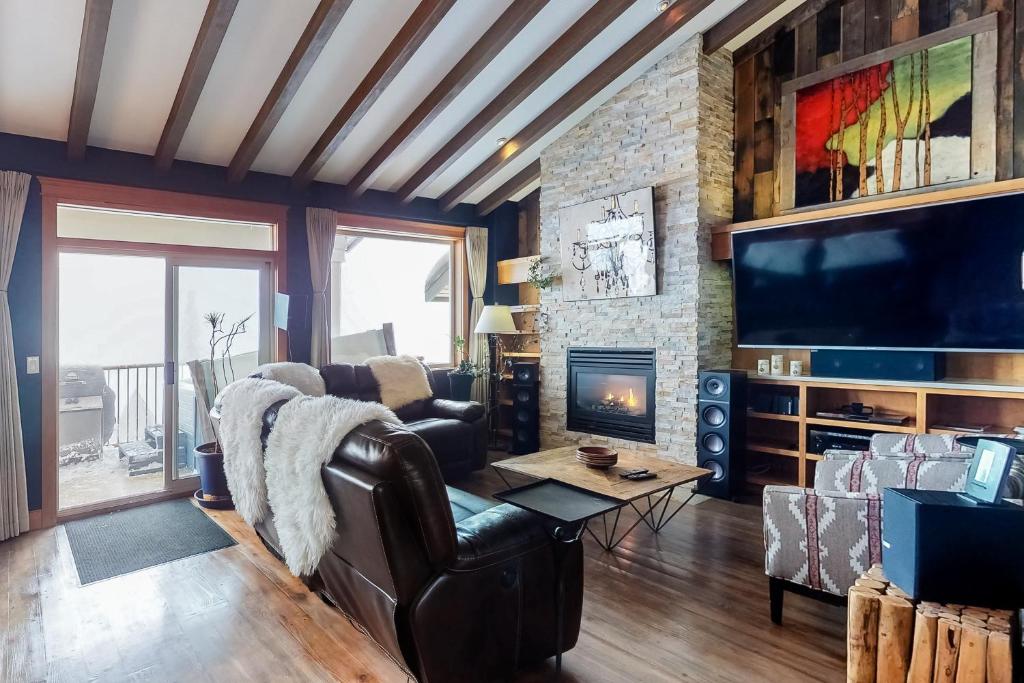 a living room with a fireplace and a tv at Tree Tops 15 in Big White