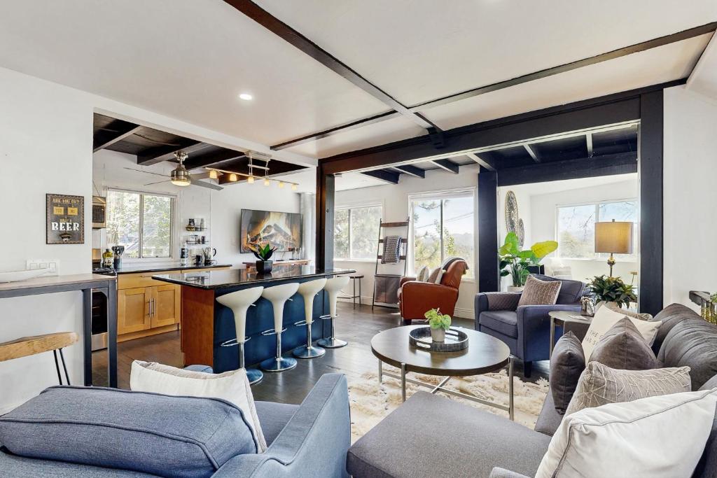a living room with blue furniture and a kitchen at The Polished Pine in Crestline