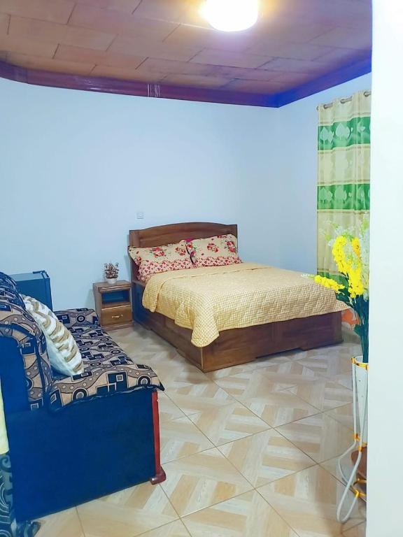 a bedroom with a bed and a couch in it at M & S Multipurpose Center in Yaoundé