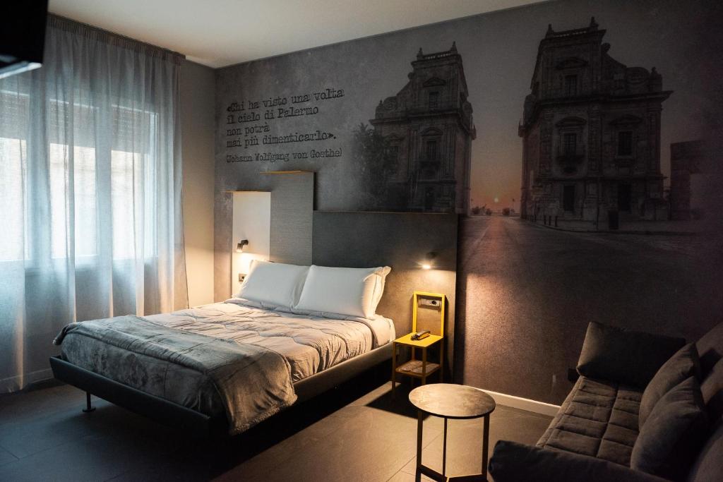 a bedroom with a bed and a chair and a couch at Alma Hotel in Palermo