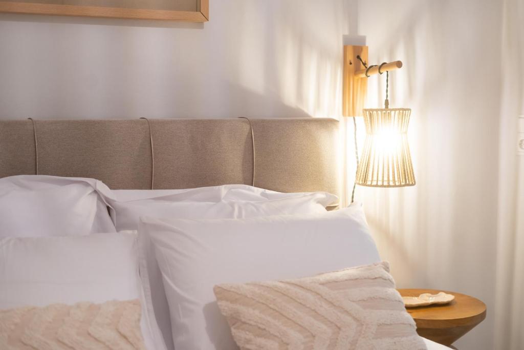 a bedroom with a bed with white pillows and a lamp at Boho Nook Apartment in Rethymno