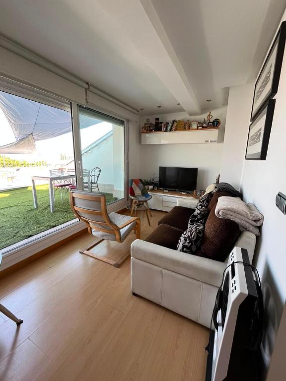 a living room with a couch and a television and a table at Atico en el centro de Vitoria Parking gratis in Vitoria-Gasteiz