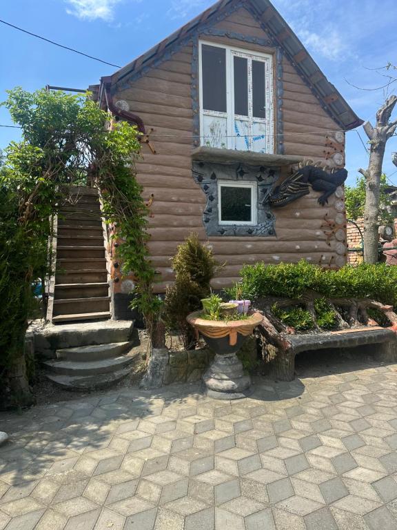a log house with a window and a staircase at Rezo's Ranch Cottage in Samtredia