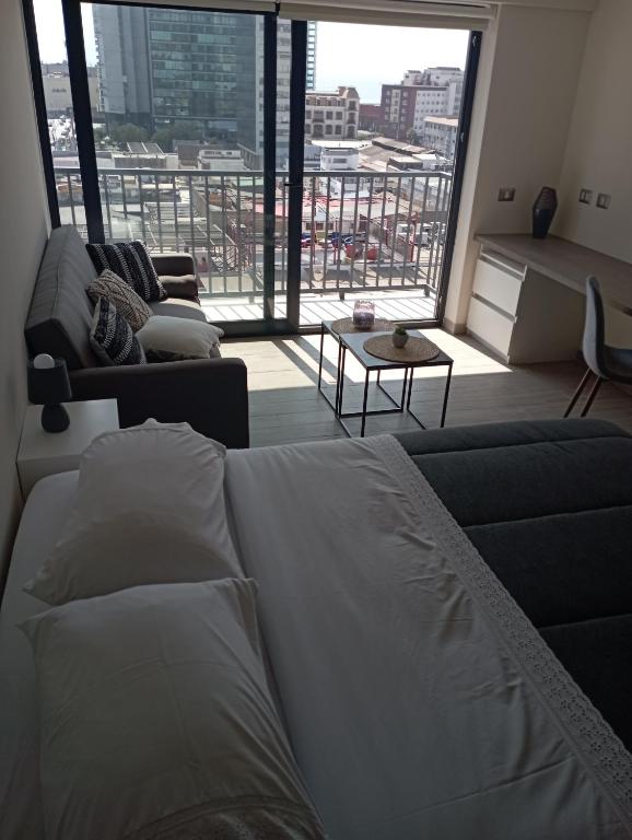 a living room with a bed and a large window at VIP Suite Antofagasta in Antofagasta
