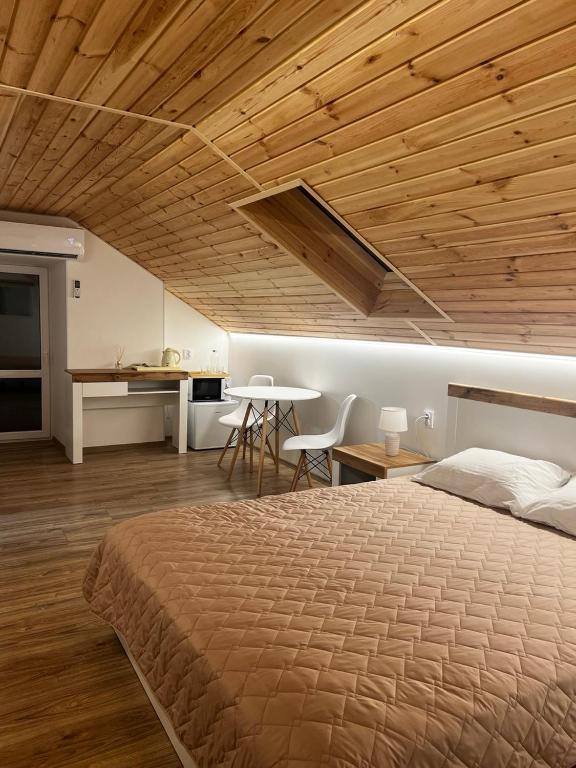a bedroom with a large bed and a wooden ceiling at Lukas Hotel in Muravitsa