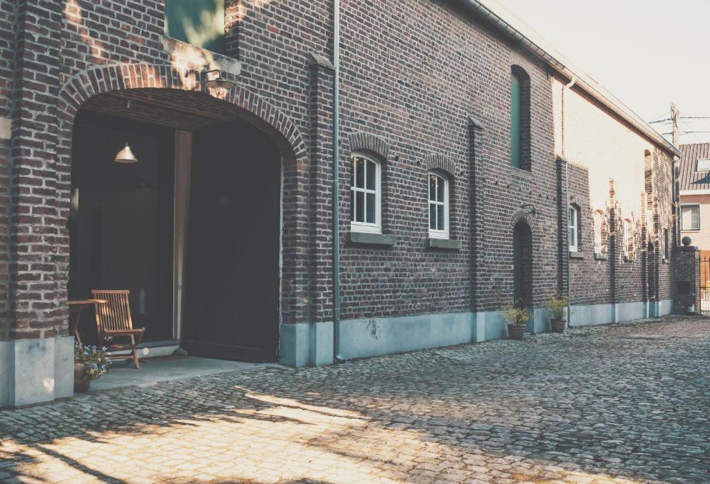 a brick building with a dog sitting in the doorway at Neerhof in Neerlinter