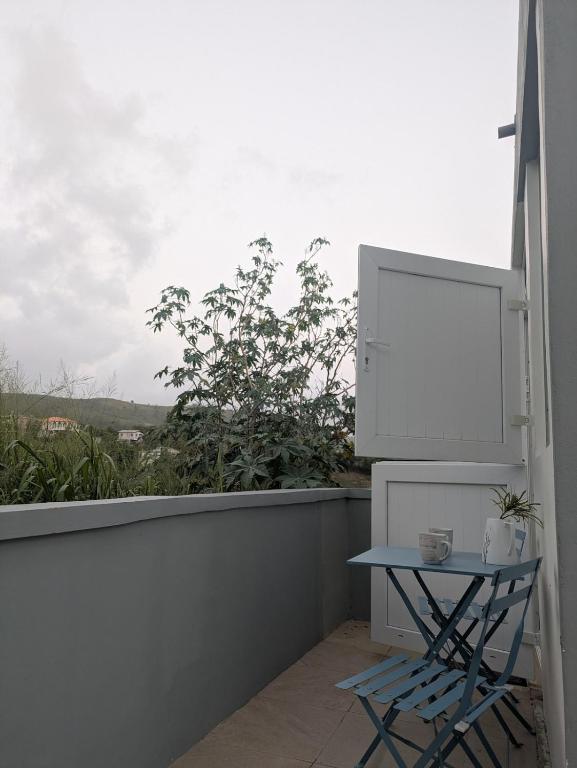a small blue table on a balcony with a window at New Beginnings in Salisbury