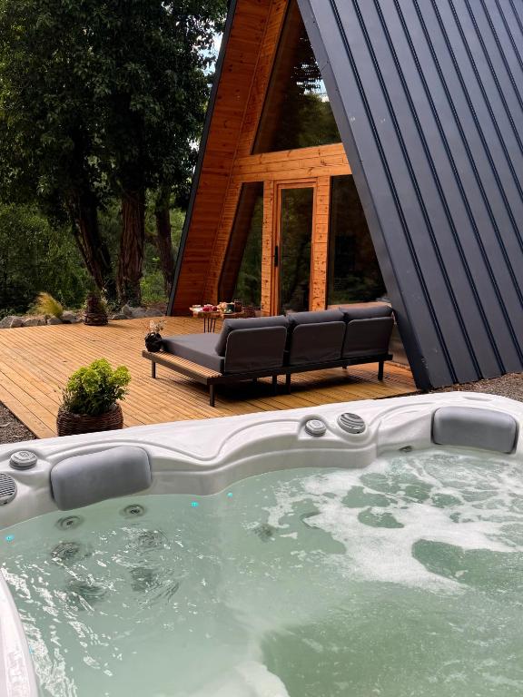 a hot tub in front of a house with a bench at Lune Dunakanyar in Esztergom