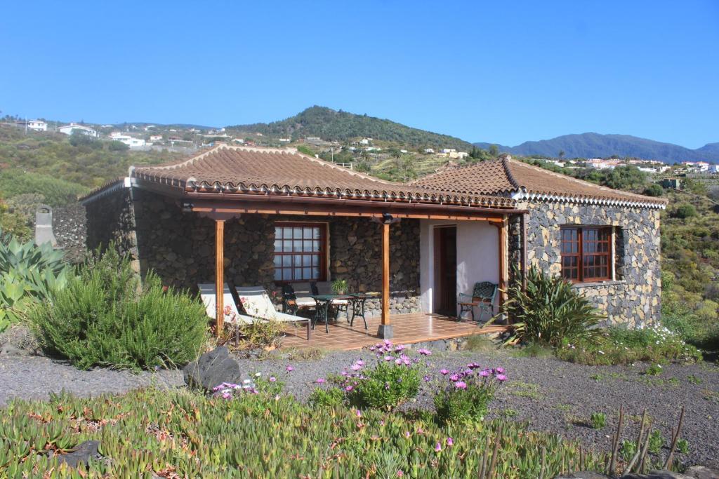 a small stone house with a wooden deck at Casa Las Caracolas in Mazo