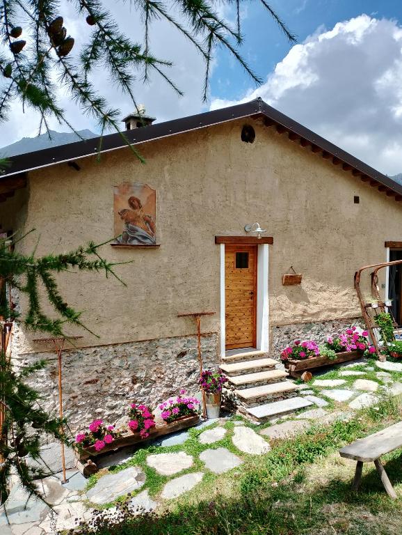 a house with a door and flowers in front of it at La Sosto de Cesi - B&B in Grange Pieccia