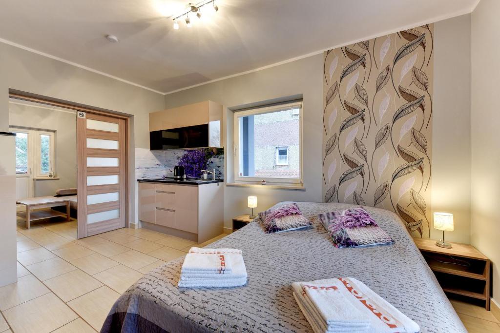 1 dormitorio con 1 cama con 2 toallas en Villa Arkodes, en Gdansk