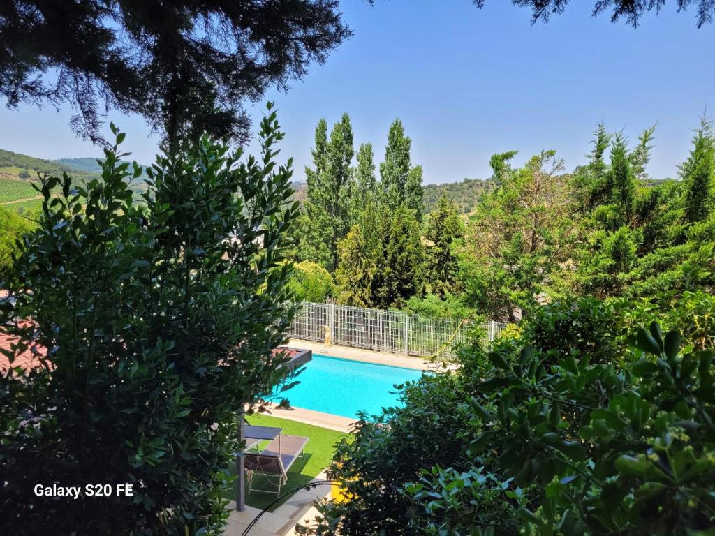 a view of the pool from the garden of a house at La symphonie des oiseaux in Villelongue-dʼAude