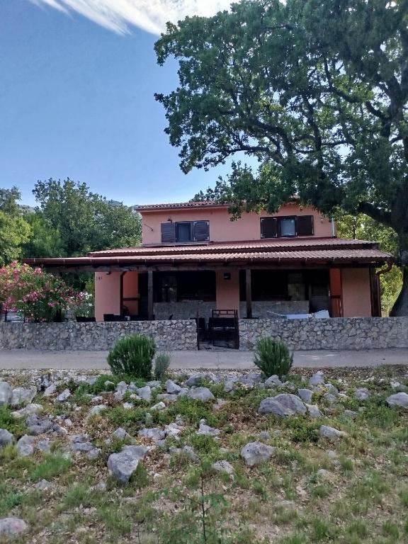 a house with a stone wall in front of it at Studio apartman Hrast in Seline