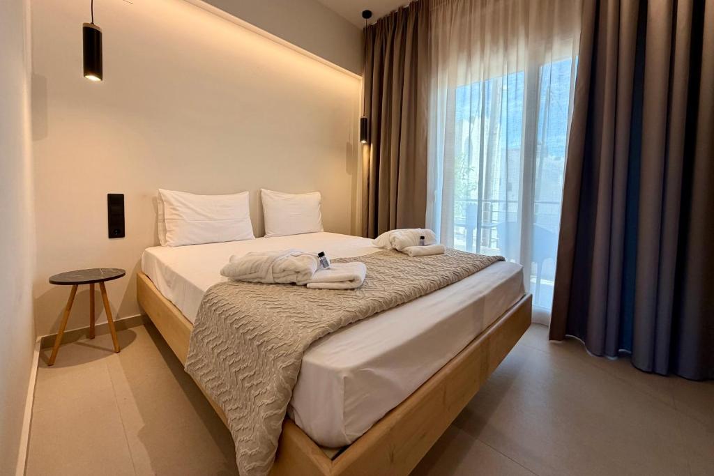 a bedroom with a bed with towels on it at GLEN Premium Stays in Kanali
