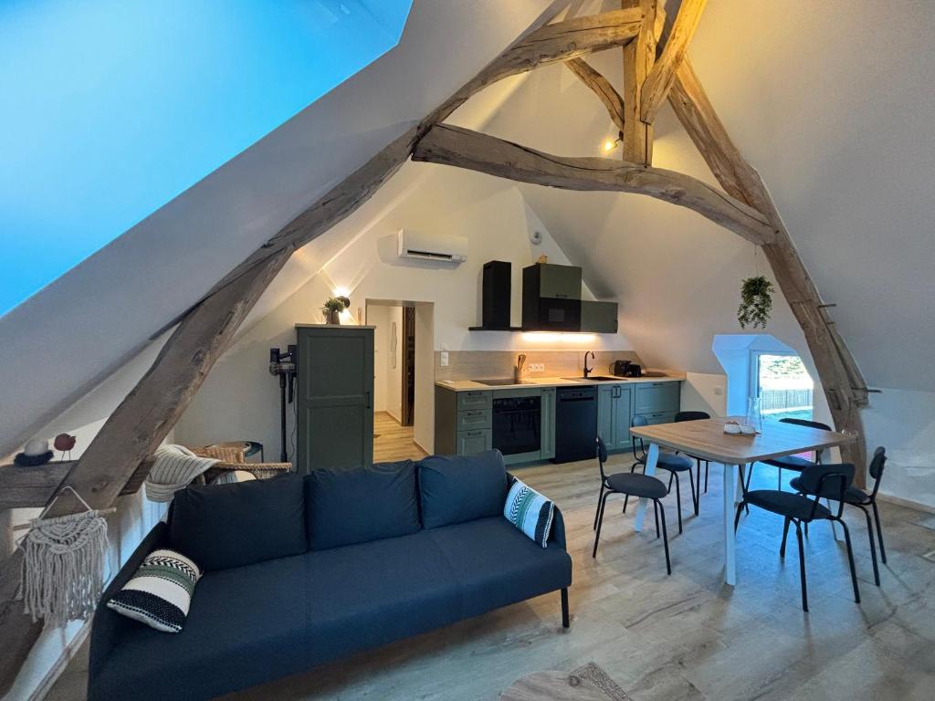 a living room with a blue couch and a table at Le Nid - Pause en Berry in Vignoux-sur-Barangeon