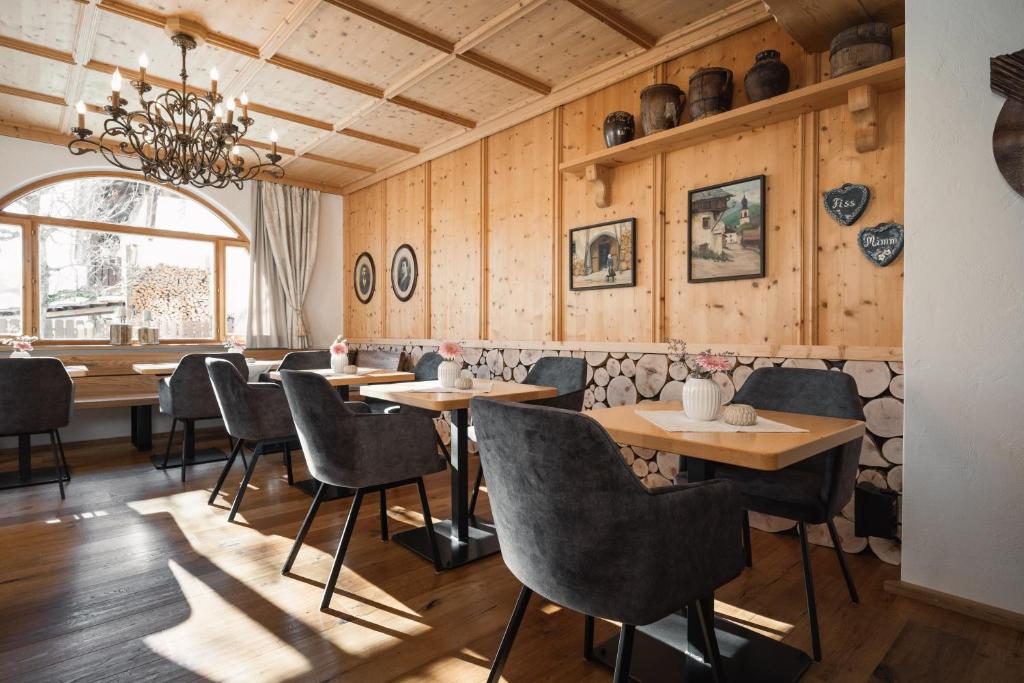 a restaurant with wooden walls and tables and chairs at Jochum Hotel Garni in Fiss